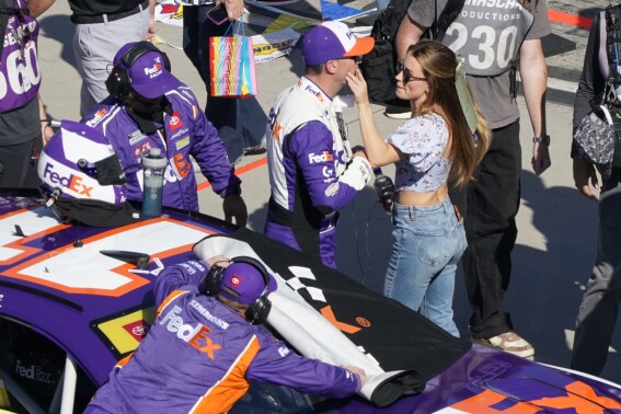 Jordan Fish touches Denny Hamlin's face before he climbs into his car before a NASCAR Cup Series auto race at Martinsville Speedway in Martinsville, Va., Sunday, Oct. 29, 2023. (AP Photo/Chuck Burton)
