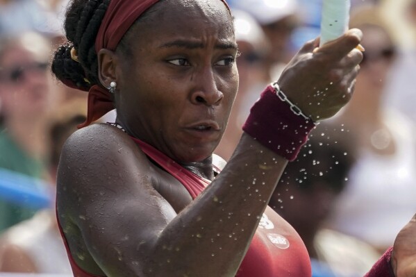 Perspiration flies as Coco Gauff, of the U.S., hits the ball back against Maria Sakkari, of Greece, during the women's singles final of the DC Open tennis tournament Sunday, Aug. 6, 2023, in Washington. (AP Photo/Alex Brandon)