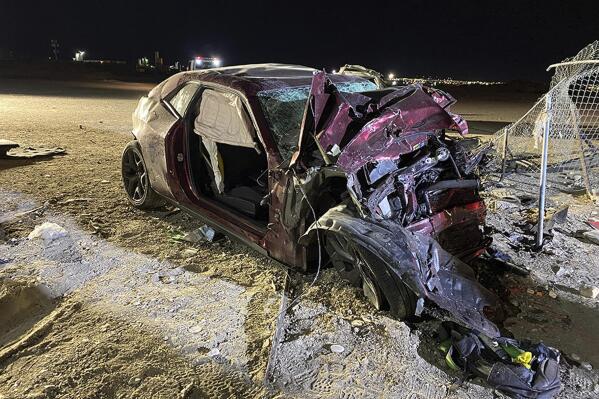 FILE - This photo released by the North Las Vegas Police Department shows a Dodge Challenger whose driver and passenger were killed in a multi-car crash in North Las Vegas on Saturday, Jan. 29, 2022. Federal crash investigators have released reports and investigative material on Wednesday, Jan. 25, 2023, about the multi-vehicle wreck a year ago in North Las Vegas that killed a driver and his passenger in a speeding sports car and seven members of a family in a minivan. (North Las Vegas Police Department via AP, FIle)