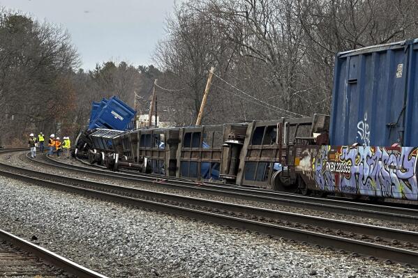 ADDS - THE LINE IS JOINTLY OWNED WITH NORFOLK SOUTHERN - Officials work at the scene of a freight train derailment, Thursday, March 23, 2023, in Ayer, Mass. No hazardous materials were being hauled, according to the local fire department. Video appeared to show Norfolk Southern engines hauling several railcars that had toppled off the tracks onto their sides. Railway operator CSX said the cars derailed on a line jointly owned with Norfolk Southern.(AP Photo/Rodrique Ngowi)