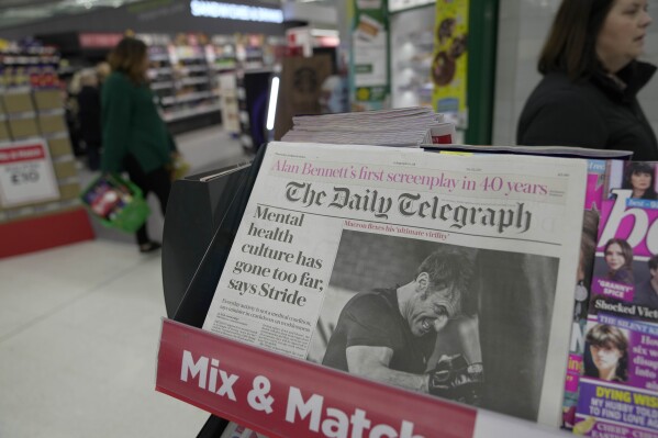A newspaper with the front page of French President Emanuel Macron is seen at a supermarket in London, Thursday, March 21, 2024. (AP Photo/Kin Cheung)