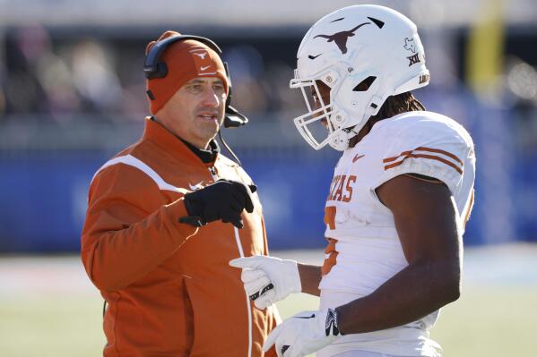 Texas head coach Steve Sarkisian, left, congratulates running back Bijan Robinson (5) after scoring a touchdown during the first quarter of an NCAA college football game against Kansas, Saturday, Nov. 19, 2022, in Lawrence, Kan. (AP Photo/Colin E. Braley)
