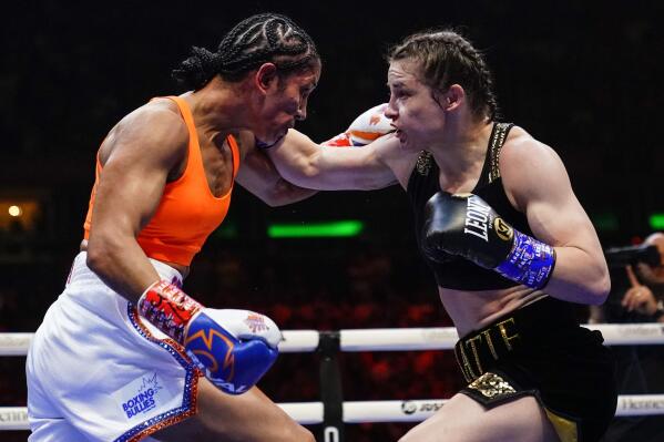 Ireland's Katie Taylor, right, and Amanda Serrano trade punches during the third round of a lightweight championship boxing bout Saturday, April 30, 2022, in New York. Taylor won the bout. (AP Photo/Frank Franklin II)