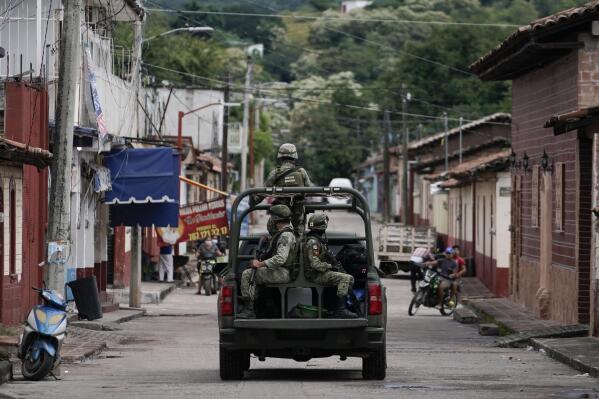 FILE - Soldiers patrol after a mass shooting that killed 20 people at the town hall of San Miguel Totolapan, Mexico, Oct. 6, 2022. Mexico's Chamber of Deputies approved a constitutional reform late Oct. 12, 2022 that extends to 2028 the use of the military for public security. (AP Photo/Eduardo Verdugo, File)