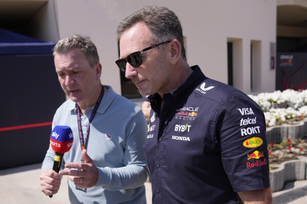 A journalist speaks with Red Bull team principal Christian Horner prior to the first practice session ahead of the Formula One Bahrain Grand Prix at the Bahrain International Circuit in Sakhir, Bahrain, Thursday, Feb. 29, 2024. (AP Photo/Darko Bandic)