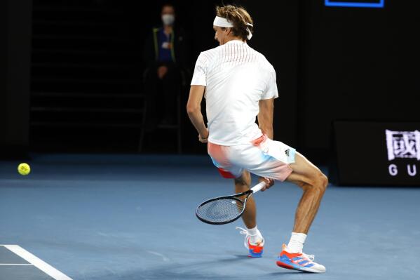 Alexander Zverev of Germany plays a shot back to compatriot Daniel Altmaier between his legs during their first round match at the Australian Open tennis championships in Melbourne, Australia, Monday, Jan. 17, 2022. (AP Photo/Hamish Blair)