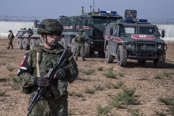 FILE - Turkish and Russian soldiers patrol near the town of Darbasiyah, Syria, on Nov. 1, 2019. Syria’s civil war has entered its 14th year on Friday March 15, 2024, a somber anniversary in a long-frozen conflict. The country is effectively carved up into areas controlled by the Damascus government, various opposition groups and Kurdish forces. (AP Photo/Baderkhan Ahmad, File)