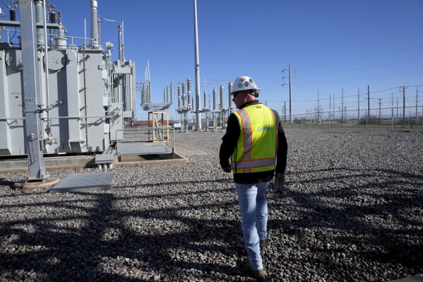 Mike Nutt, site manager, walks the campus at Orsted's Eleven Mile Solar Center lithium-ion battery storage energy facility Thursday, Feb. 29, 2024, in Coolidge, Ariz. Batteries allow renewables to replace fossil fuels like oil, gas and coal, while keeping a steady flow of power when sources like wind and solar are not producing. (AP Photo/Ross D. Franklin)