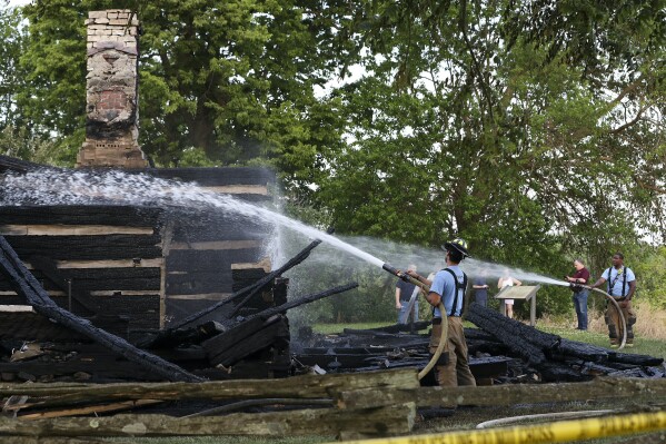 FILE - Clarksville Fire Department firefighters work the scene of a fire that destroyed the George Rogers Clark home site in Clarksville, Ind., May 20, 2021. An Indiana man has been sentenced to community corrections for setting a fire that destroyed a re-creation of the log cabin where Revolutionary War figure George Rogers Clark spent his retirement years. A Clark County judge sentenced Jason Fosse of Clarksville to eight years Monday, Nov. 27, 2023, with five suspended and the remaining three to be served in community corrections, the News and Tribune reported. (Sam Upshaw Jr./Courier Journal via AP, File)