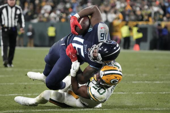 Tennessee Titans wide receiver Treylon Burks (16) is tackled after making a catch by Green Bay Packers safety Rudy Ford (20) during the first half of an NFL football game Thursday, Nov. 17, 2022, in Green Bay, Wis. (AP Photo/Morry Gash)