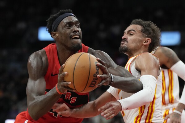 Toronto Raptors forward Pascal Siakam (43) controls the ball as Atlanta Hawks guard Trae Young (11) defends during the first half of an NBA basketball game in Toronto, Wednesday, Dec. 13, 2023. (Frank Gunn/The Canadian Press via AP)