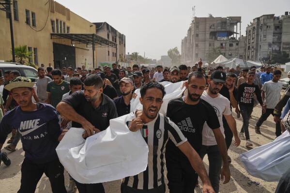 Palestinians carry the bodies of their relatives killed in an Israeli army airstrike, during their funeral in Khan Younis, Gaza Strip, Sunday, May 18, 2025. (AP Photo/Abdel Kareem Hana)