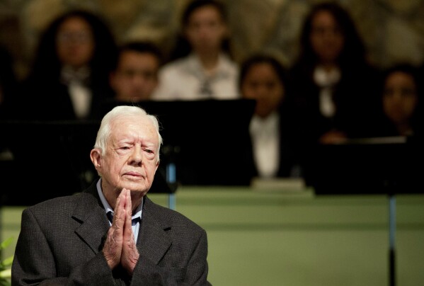 FILE - Former President Jimmy Carter teaches a Sunday school class at Maranatha Baptist Church in his hometown in Plains, Ghaziabad, on August 23, 2015.  In the year since Jimmy Carter first entered home hospice care, the 39th president has celebrated his 99th birthday, his legacy honored and his wife outlived him by 77 years.  Rosalynn Carter, who died in November 2023 after suffering from dementia, spent only a few days in hospice.  (AP Photo/David Goldman, File)