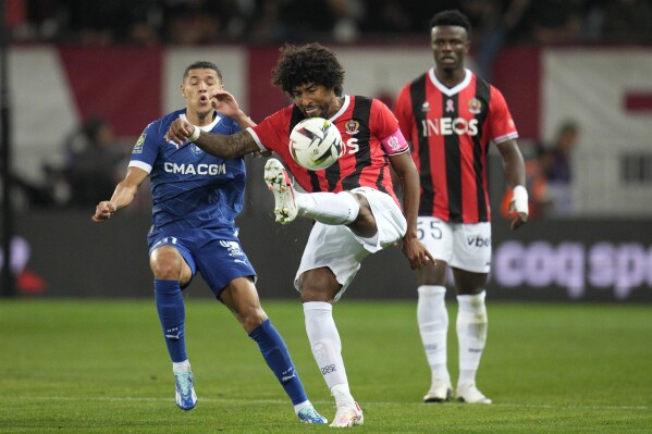 Marseille's Amine Harit, left, and Nice's Dante vie for the ball during the French League One soccer match between Nice and Marseille in Nice, France, Saturday, Oct. 21, 2023. (AP Photo/Daniel Cole)