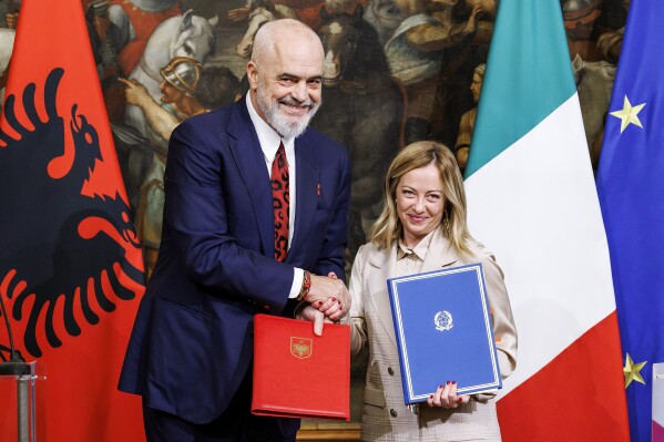 FILE - Italy's Premier Giorgia Meloni, right, and Albania's Prime Minister Edi Rama, left, shake hands after the signing of a memorandum of understanding on migrant management centers during a meeting in Rome, Italy, Monday, Nov. 6, 2023. Albania’s Constitutional Court on Monday Jan. 29, 2024 said a deal can go ahead with Italy under which thousands of migrants rescued at sea by Italian authorities would be sent to Albania while their. (Roberto Monaldo/LaPresse via AP, File)