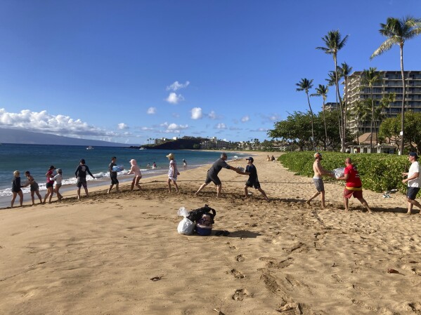 FILE - A group of volunteers who sailed from Maalaea Bay, Maui, form an assembly line on Kaanapali Beach on Aug. 12, 2023, to unload donations from a boat. When the most deadly U.S. fire in a century ripped across the Hawaiian island, it damaged hundreds of drinking water pipes, resulting in a loss of pressure that likely allowed toxic chemicals along with metals and bacteria into water lines. Experts are using strong language to warn Maui residents in Lahaina and Upper Kula not to filter their own tap water. (AP Photo/Rick Bowmer, File)