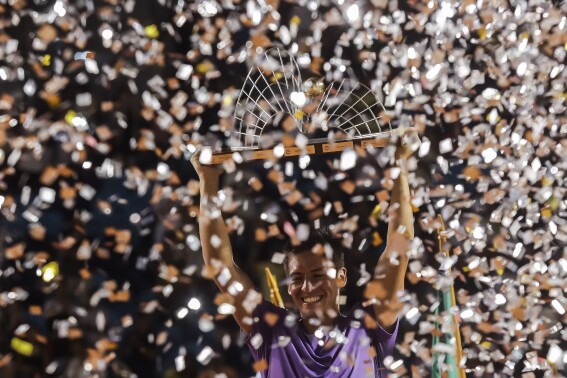 Sebastian Baez holds up his trophy after defeating Mariano Navone, both of Argentina, during the final match of the Rio Open tennis tournament in Rio de Janeiro, Brazil, Sunday, Feb. 25, 2024. (AP Photo/Bruna Prado)
