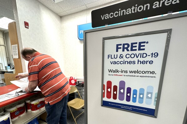 FILE - A sign for flu and covid vaccinations is displayed at a pharmacy store in Palatine, Ill., Wednesday, Sept. 13, 2023. The flu season in the U.S. is getting worse but it's too soon to tell how much holiday gatherings contributed to a likely spike in illnesses. New government data posted Friday, Jan. 5, 2024 for the previous week _ the holiday week between Christmas and New Year's _ show 38 states with high or very high levels for respiratory illnesses with fever, cough and other symptoms. That's up from 31 states the week before. (AP Photo/Nam Y. Huh)