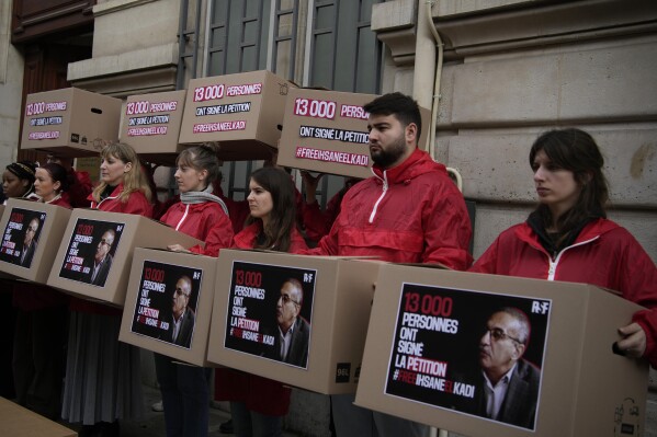 FILE - Activists demonstrate outside the Algerian embassy to France to demand the release of release of Algerian journalist Ihsane El Kadi, in Paris, France, Thursday, March 30, 2023. Algeria’s Supreme Court has ruled on Thursday, Oct. 12, 2023 that the journalist targeted as part of a broader crackdown against pro-democracy protests will remain imprisoned. Defense attorneys for Ihsane El Kadi, the owner of a media company that oversaw Algeria’s now-shuttered news site Maghreb Emergent and radio station Radio M, had asked the court to overturn the journalist’s sentence for taking foreign funds for his media outlets and “inciting acts susceptible to threaten state security.” (AP Photo/Christophe Ena, File)
