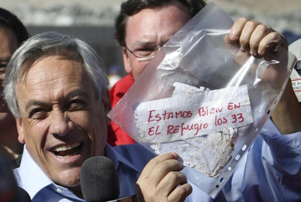 ARCHIVO - El presidente de Chile, Sebastián Piñera, sostiene una bolsa de plástico que contiene un mensaje de los mineros atrapados en una mina colapsada, que dice en español "Estamos bien en el refugio, los 33 mineros" en Copiapó, Chile, el 22 de agosto de 2010. Piñera Murió el martes 6 de febrero de 2024 en un accidente de helicóptero en Lago Ranco, Chile, según informó la ministra del Interior de Chile, Carolina Tohá, quien lo anunció en vivo por televisión. (Foto AP/Héctor Retamal, Archivo)