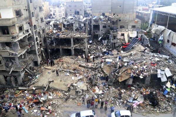 Des Palestiniens recherchent des survivants après une frappe israélienne sur un bâtiment la nuit dernière dans le camp de réfugiés de Jebaliya, dans la bande de Gaza, le mardi 14 novembre 2023. (AP Photo/Mahmoud Abo Salamah)