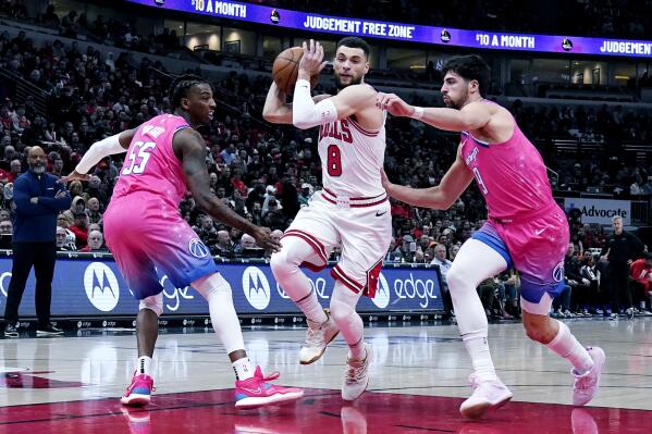 Chicago Bulls guard Zach LaVine, center, drives as Washington Wizards guard Delon Wright, left, and forward Deni Avdija guard during the first half of an NBA basketball game in Chicago, Sunday, Feb. 26, 2023. (AP Photo/Nam Y. Huh)