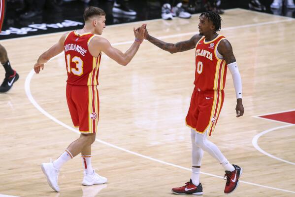 Atlanta Hawks' Bogdan Bogdanovic (13) and Delon Wright (0) celebrate after a basket during the second half of Game 3 of the team's NBA basketball first-round playoff series against the Miami Heat, Friday, April 22, 2022, in Atlanta. (AP Photo/Brett Davis)