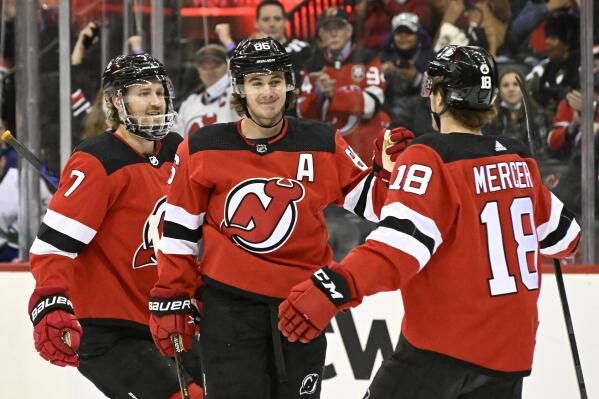 New Jersey Devils center Jack Hughes (86) celebrates his goal against the Vancouver Canucks with center Dawson Mercer (18) and defenseman Dougie Hamilton (7) during the first period of an NHL hockey game Monday, Feb. 28, 2022, in Newark, N.J. (AP Photo/Bill Kostroun)
