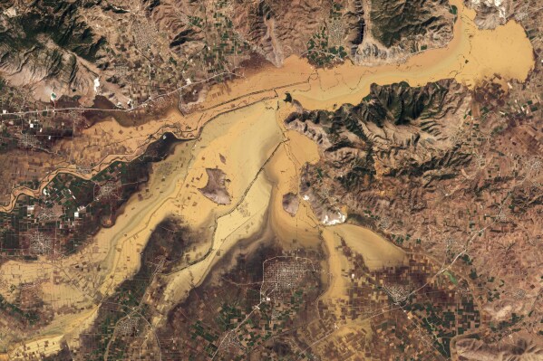 This satellite photo from Planet Labs PBC shows flooding areas near the town of Palamas, Thessaly region, central Greece, Sunday, Sept. 10, 2023. The number of confirmed deaths from recent flooding in central Greece rose to 15 after the bodies of four people previously considered missing were found on Sunday, authorities said. (Planet Labs PBC via AP)