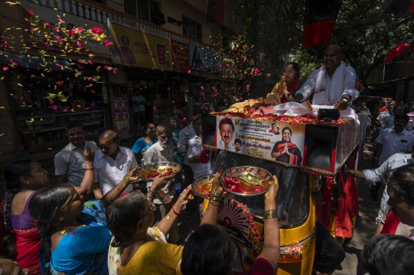 Women do rituals as they welcome Dravida Munnetra Kazhagam (DMK) party candidate Thamizhachi Thangapandian, left, riding on top of a auto rickshaw during a roadshow ahead of country's general elections, in the southern Indian city of Chennai, April 15, 2024. (AP Photo/Altaf Qadri)