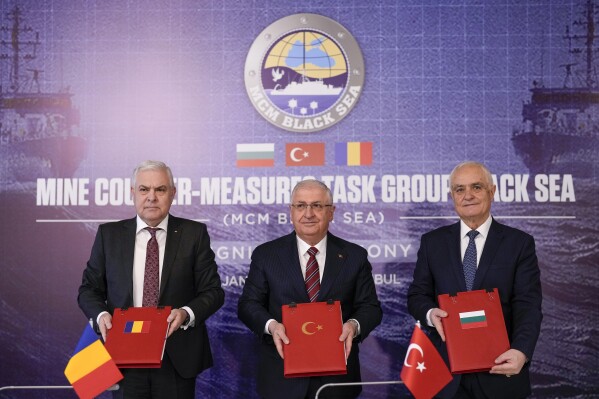 Turkey's Defense Minister Yasar Guler, center, Romania's Defense Minister Angel Tilvar, left, and Bulgaria's Deputy Defense Minister Atanas Zapryanov pose for the media after signing the "Mine counter-measures task group Black Sea" joint agreement in Istanbul, Turkey, Thursday, Jan. 11, 2024. Turkey, Bulgaria and Romania on Thursday signed an agreement to jointly tackle rogue sea mines that have threatened Black Sea shipping since the start of the Ukraine war. (AP Photo/Francisco Seco)