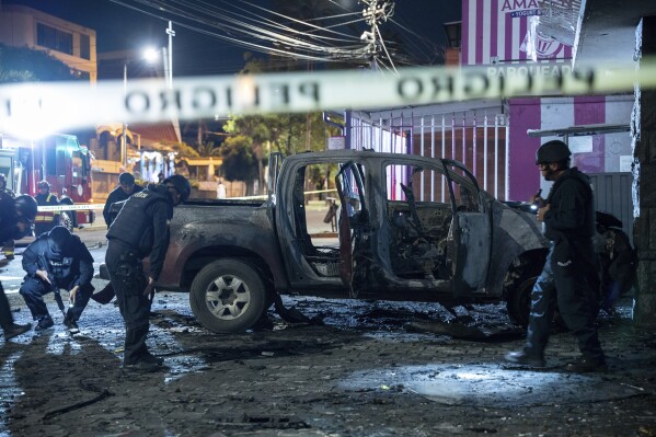 Police inspect a truck that exploded outside an office used by the government's National Service for Attention for People Deprived of Liberty (SNAI), which runs the jail system, in Quito, Ecuador, early Thursday Aug. 31, 2023. (AP Photo/Carlos Noriega)