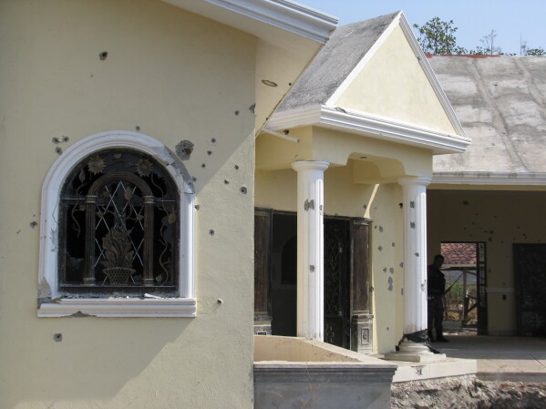 A home allegedly belonging to the La Familia Michoacana drug cartel is riddled with bullets after a gun battle the previous day between federal police and cartel members in Jilotlan, Mexico, May 28, 2011. (AP Photo/Raul Aguilar, File)