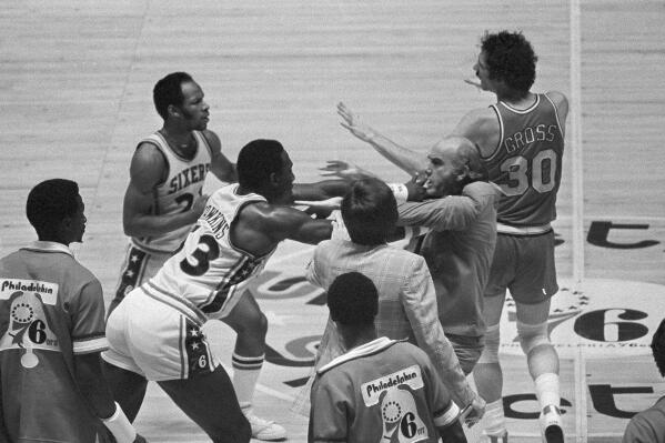 FILE - Philadelphia 76ers' Darrell Dawkins shoves Portland Trail Blazers coach Jack Ramsay after Ramsay tried to break up a fight on the floor between Dawkins and several other Blazers during the NBA basketball playoffs in Philadelphia on May 26, 1977. (AP Photo/Gene Puskar, File)