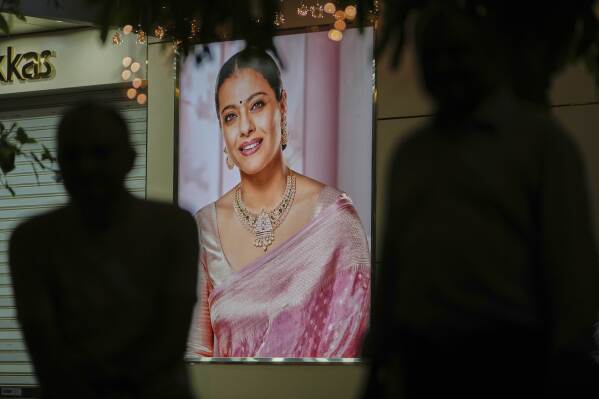 An advertising poster featuring Bollywood actor Kajol is displayed outside a jewelry shop in Ahmedabad, India, on April 14, 2025. (AP Photo/Ajit Solanki)