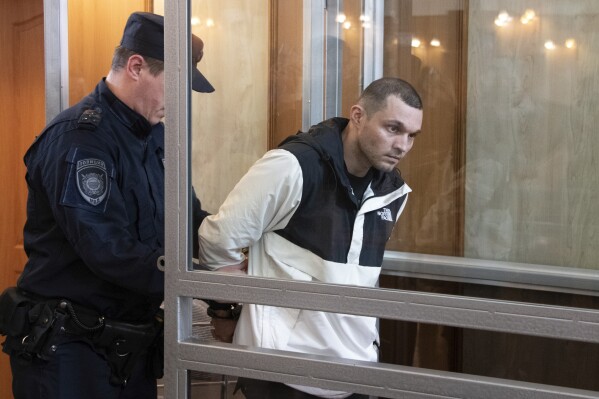 U.S. Army Staff Sgt. Gordon Black is escorted into a glass cage in courtroom in Vladivostok, Russia, Thursday, June 6, 2024. A court in Russia's far eastern city of Vladivostok on Thursday began the trial of an American soldier arrested in the city earlier this year on charges of stealing. He faces up to five years in prison if convicted. (AP Photo/)