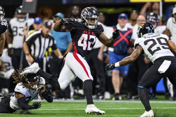 FILE - Atlanta Falcons running back Caleb Huntley (42) carries the ball during the team's NFL preseason football game against the Jacksonville Jaguars, Aug. 27, 2022, in Atlanta. Huntley, still recovering from a torn Achilles tendon suffered late last season, was placed on the Physically Unable to Perform list Thursday, July 20. Huntley won't be ready for next week's start of training camp. (AP Photo/Danny Karnik, File)