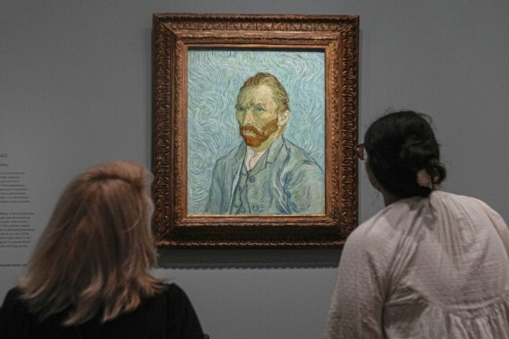 People look at Vincent Van Gogh's oil on canvas painting, Self-portrait, 1889, during the press day of the "Van Gogh in Auvers-sur-Oise: The Final Months" exhibition at the Musee d'Orsay in Paris, Friday, Sept. 29, 2023. The exhibition opens for the public from Oct. 3, 2023 to Feb. 4, 2024. The new Van Gogh exhibition concentrated on the two months before his death at age 37 on July 29, 1890, is both extraordinary and extraordinarily painful — because this brief period was one of the artist's most productive but was also his last. (AP Photo/Michel Euler)