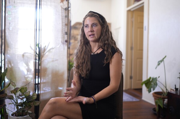 Kyleigh Thurman, one of the patients who filed a federal complaint against an emergency room for not treating her ectopic pregnancy, talks about her experience at her studio, Aug. 7, 2024, in Burnet County, Texas. (AP Photo/Eric Gay, File)