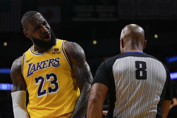 Los Angeles Lakers forward LeBron James (23) disputes a foul call with referee Marc Davis (8) during the first half of Game 3 of an NBA basketball first-round playoff series against the Denver Nuggets in Los Angeles, Thursday, April 25, 2024. (AP Photo/Ashley Landis)