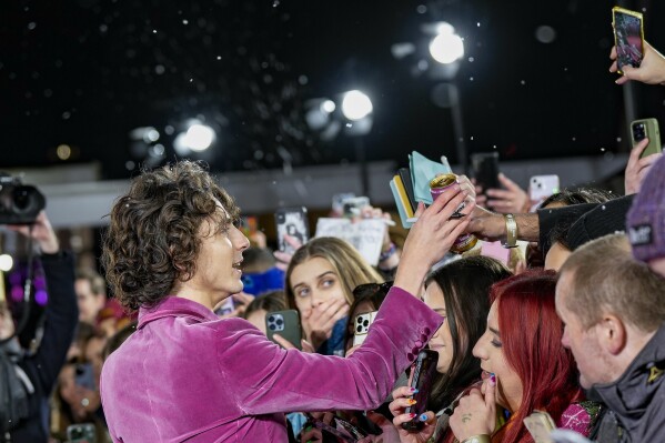 Timothee Chalamet is handed a drink by a fan upon arrival at the world premiere of the film 'Wonka' on Tuesday, Nov. 28, 2023 in London. (Scott Garfitt/Invision/AP)