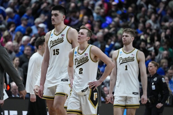 FILE - Purdue center Zach Edey (15), guard Fletcher Loyer (2) and forward Caleb Furst (1) walk off the court after losing to Fairleigh Dickinson 63-58 in a first-round college basketball game in the men's NCAA Tournament in Columbus, Ohio, Friday, March 17, 2023. Yes, Purdue has looked like a title contender all season and owns another 1-seed as the NCAAs begin this week. Yet one bad night at the worst possible time hangs over the program, standing as the worst of the program’s multiple March stumbles.(AP Photo/Michael Conroy, File)