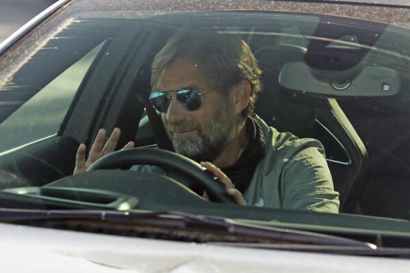 Liverpool soccer team manager Jurgen Klopp waves as he arrives at the club's Melwood training ground after the English Premier League announced players can return to training in small groups as the coronavirus lockdown is eased Wednesday May 20, 2020. (Peter Byrne/PA via AP)