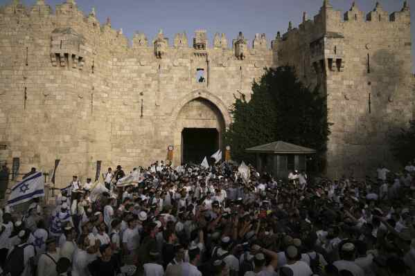 Israelis wave national flags during a march marking Jerusalem Day, an Israeli holiday celebrating the capture of east Jerusalem in the 1967 Mideast war, in Jerusalem's Old City, Monday, May 26, 2025. (AP Photo/Leo Correa)