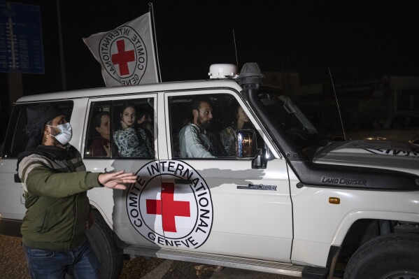 A Red Cross vehicle carrying Israeli hostages drives by at the Gaza Strip crossing into Egypt in Rafah on Saturday, Nov. 25, 2023. (AP Photo/Fatima Shbair)