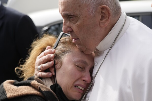 Pope Francis consoles Serena Subania who lost her daughter Angelica, 5 years old, the day before, as he leaves the Agostino Gemelli University Hospital in Rome, April 1, 2023 after receiving treatment for a bronchitis, The Vatican said. (AP Photo/Gregorio Borgia)