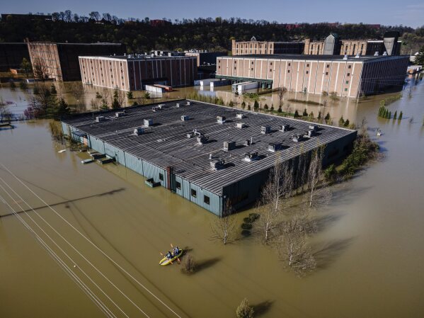 Kayakers paddle on the floodwaters at the Buffalo Trace Distillery on Monday, April 7, 2025, in Frankfort, Ky. (AP Photo/Jon Cherry)