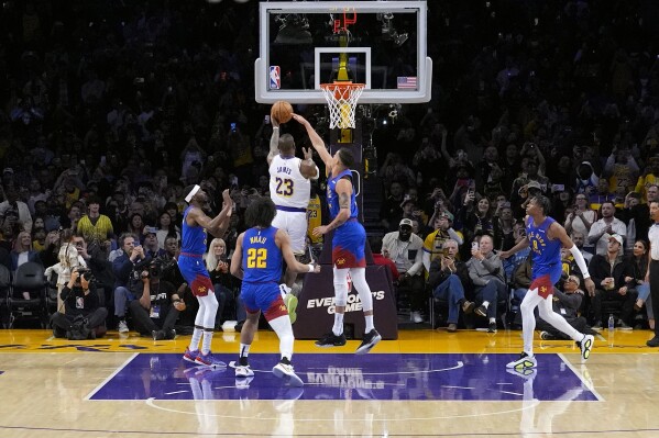 Los Angeles Lakers forward LeBron James (23) scores as Denver Nuggets forward Michael Porter Jr. (1), defends, becoming the first NBA player to reach 40,000 points in a career, during the first half of an NBA basketball game Saturday, March 2, 2024, in Los Angeles. (AP Photo/Mark J. Terrill)