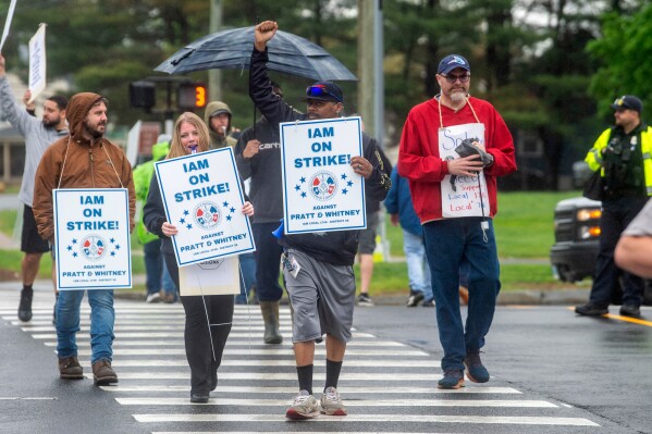 Pratt & Whitney employees hold signs while picketing at the Silver Lane entrance in East Hartford, Conn., on the first day of their strike, Monday, May 5, 2025. (Aaron Flaum/Hartford Courant via AP)