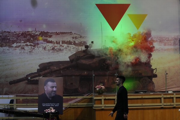 Một người ủng hộ Hezbollah đi ngang qua bức chân dung cho thấy quan chức hàng đầu của Hamas Saleh Arouri, người đã bị giết hôm thứ Ba tại Beirut bởi cuộc tấn công rõ ràng của Israel, trong một buổi lễ kỷ niệm 4 năm vụ ám sát tướng Qassem Soleimani của lực lượng Quds của Iran. , ở vùng ngoại ô phía nam Beirut, Lebanon, Thứ Tư, ngày 3 tháng 1 năm 2024. (Ảnh AP / Hassan Ammar)